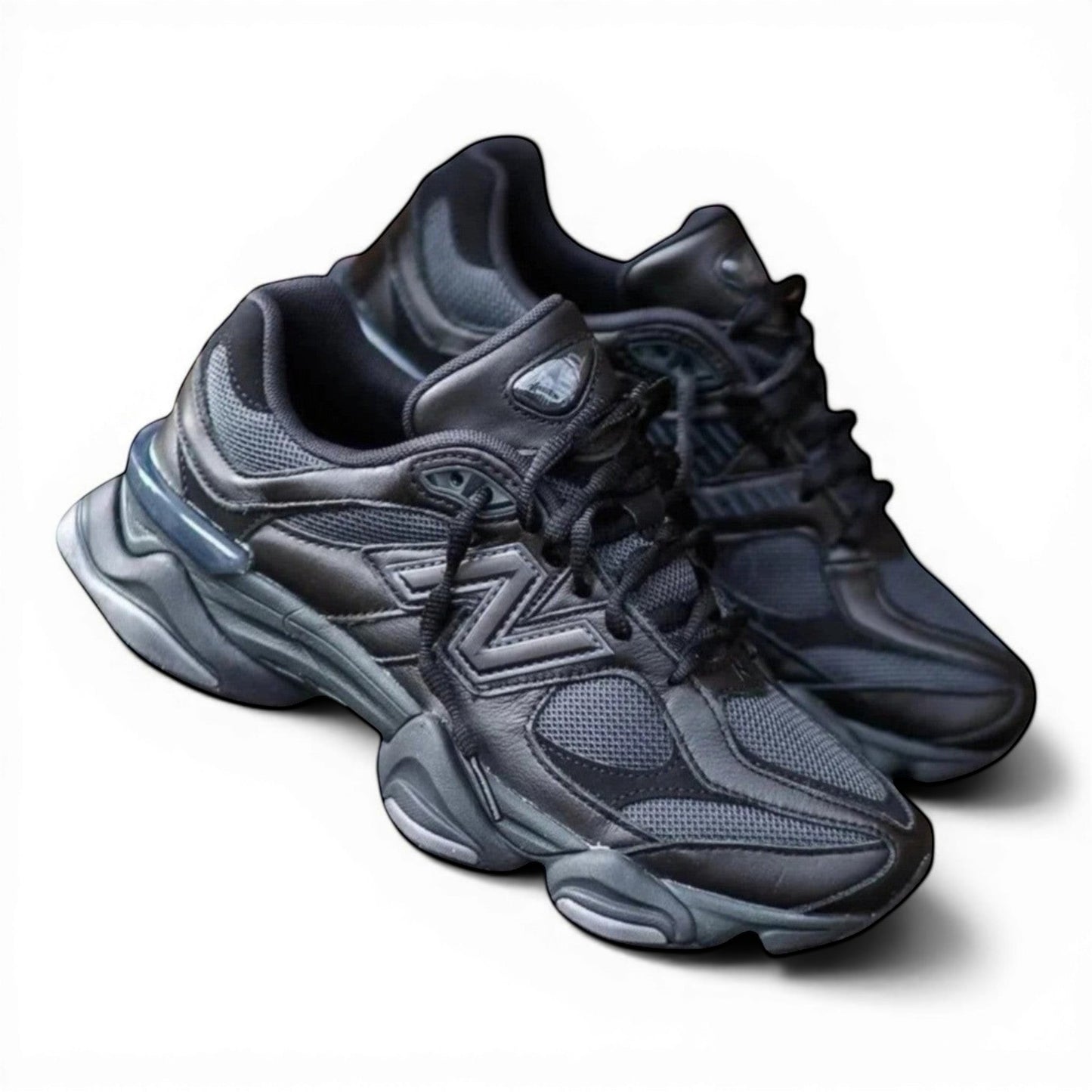 Urbanstyle New Balance 9060 Triple Black sneakers with mesh and leather upper, chunky sole, and lace-up closure.