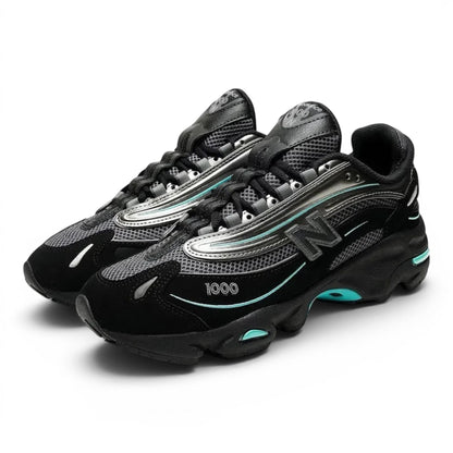 urbanstyle New Balance 1000 sneakers in black and metallic silver with teal accents, featuring mesh and suede layers.