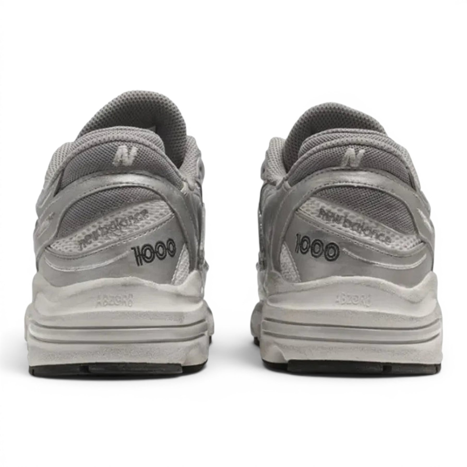Rear view of metallic silver New Balance 1000 lifestyle sneakers from urbanstyle with ABZORB cushioning and mesh upper.