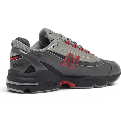 urbanstyle New Balance 1000 lifestyle running shoe in metallic silver and dark grey with red accents.