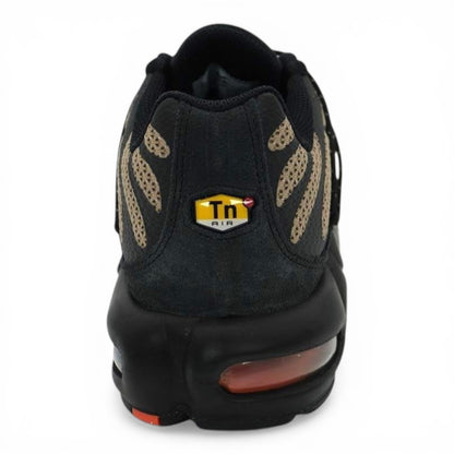 Nike Air Max Plus sneakers with tan and black tiger-stripe mesh, black overlays, and Tuned Air cushioning.