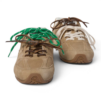 Urbanstyle tan suede low-top athletic sneakers with contrasting green and brown laces. Retro design, rubber sole.